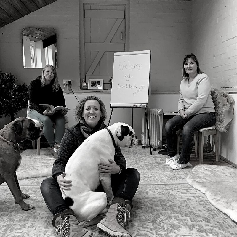 Black and white picture of Ali with a dog sat in her lap