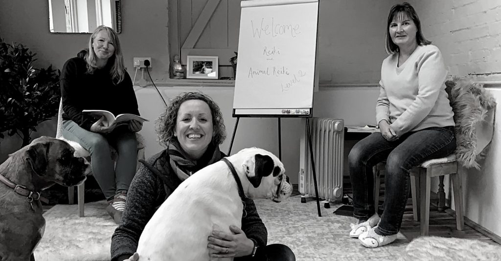 Black and white picture of Ali with a dog sat in her lap